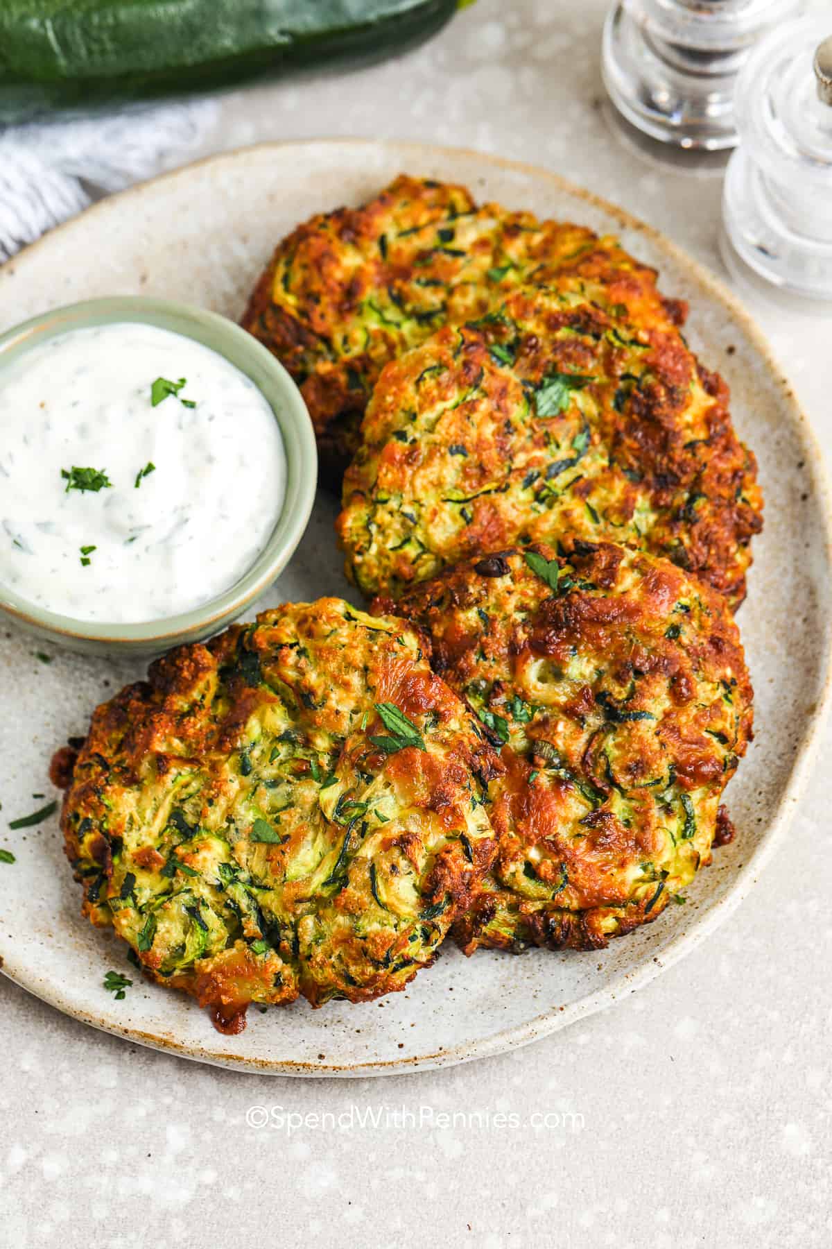 zucchini fritter patties on a plate with ranch