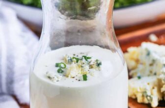 a prepared cobb salad in a salad bowl with creamy dressing, eggs and avocados