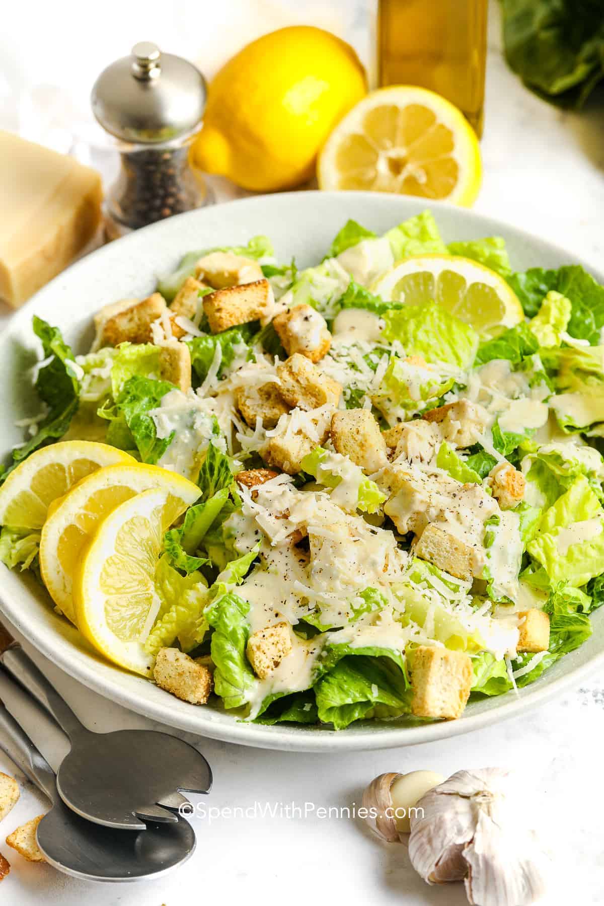 a bowl of caesar salad with lemons