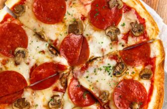 overhead view of a tortilla pizza with pepperoni and mushrooms