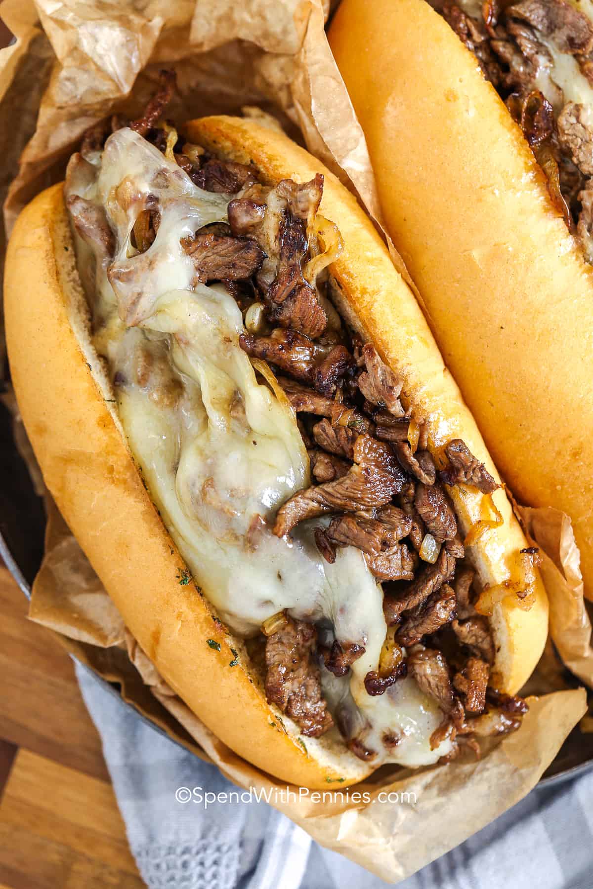 philly cheesesteak topped with cheese in a roll