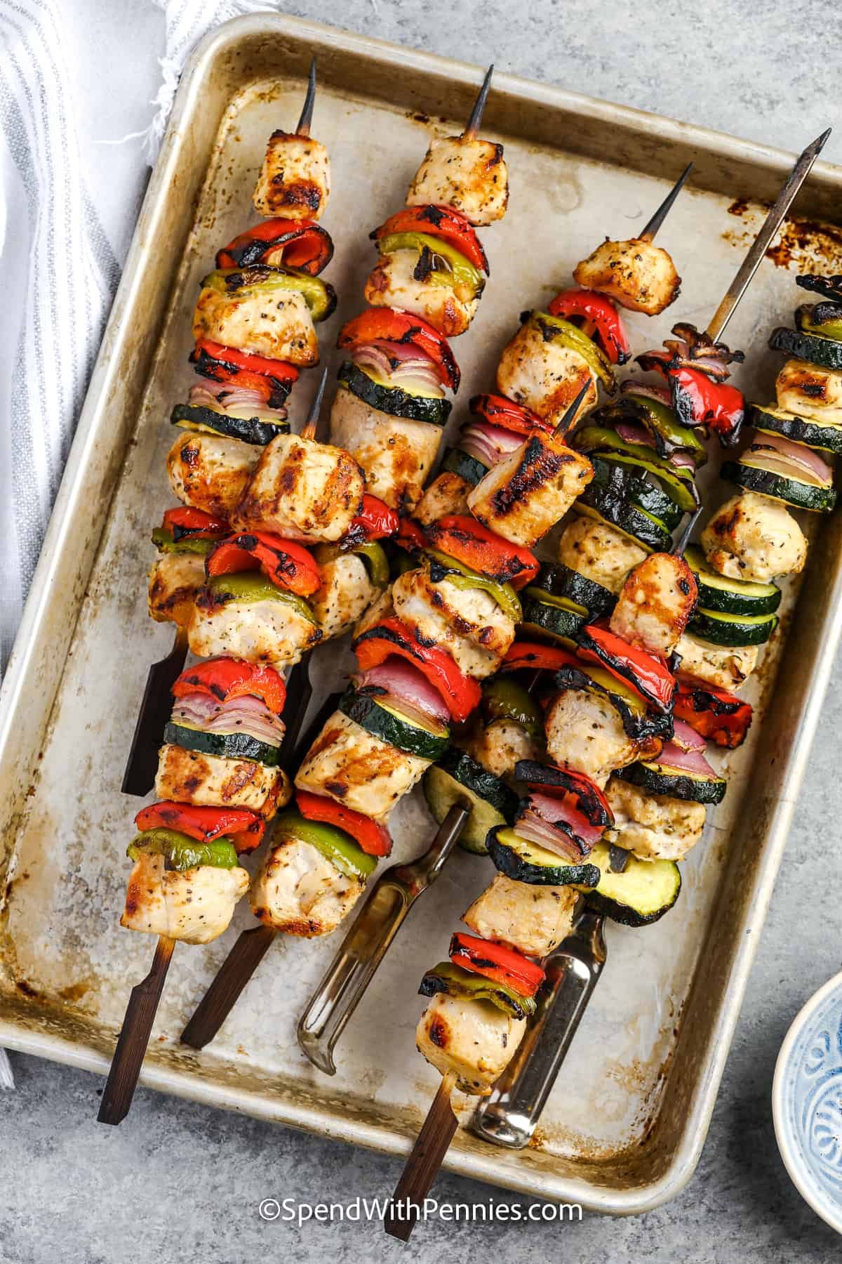cooked greek chicken kabobs on a metal tray