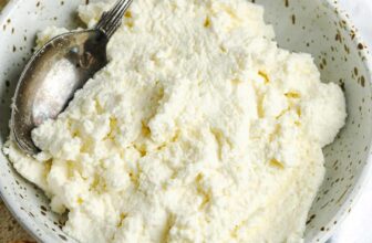 a bowl of homemade ricotta cheese next to crostini