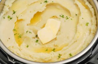 mashed potatoes in an Instant Pot with pats of butter and parsley as garnish