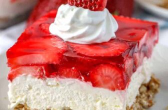 Strawberry Pretzel Salad on a plate with whipped cream and strawberry as garnish
