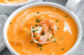 a bowl of shrimp bisque with shrimp and chives on top