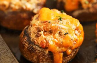 close up of Sausage Stuffed Mushrooms on a sheet pan