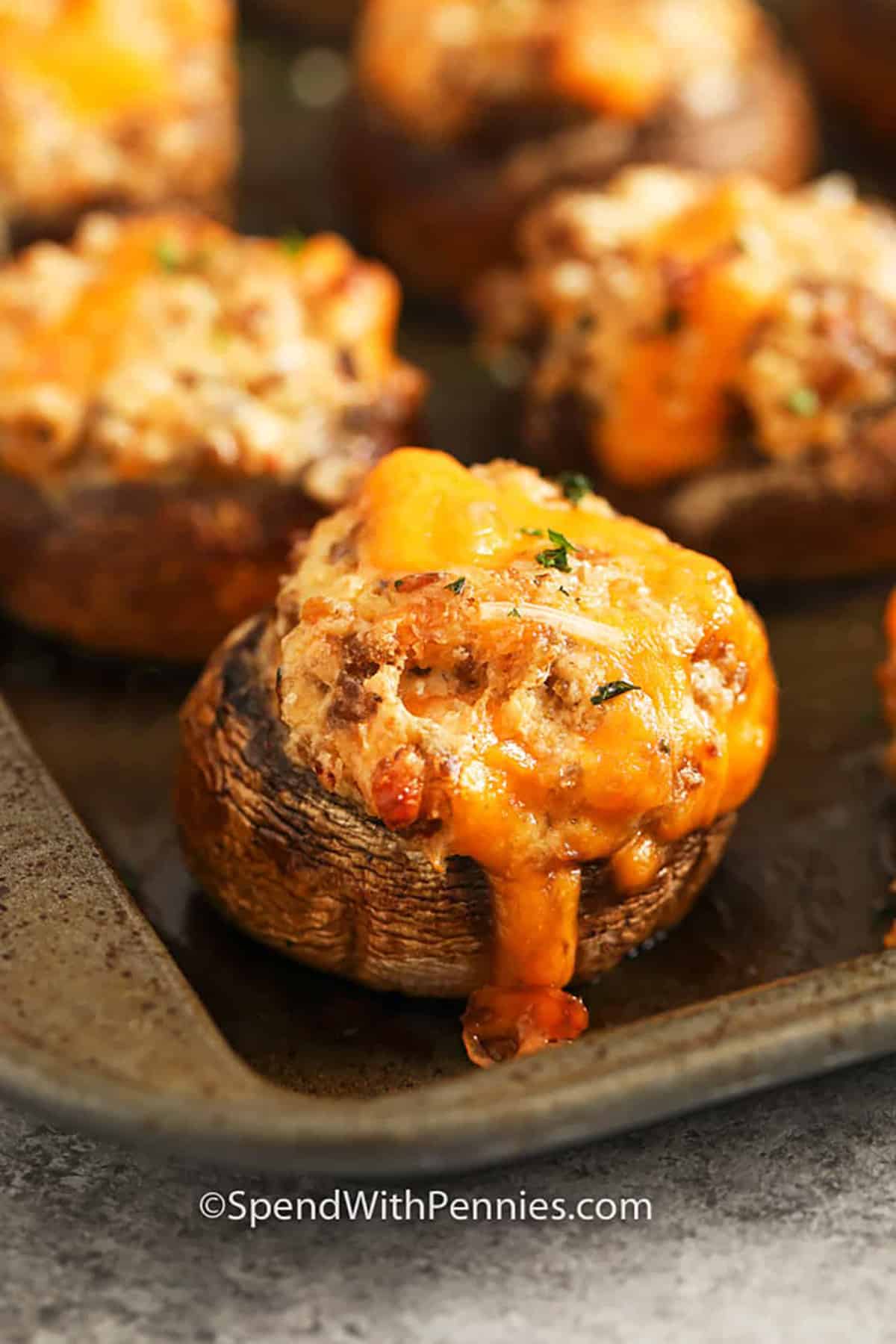close up of Sausage Stuffed Mushrooms on a sheet pan
