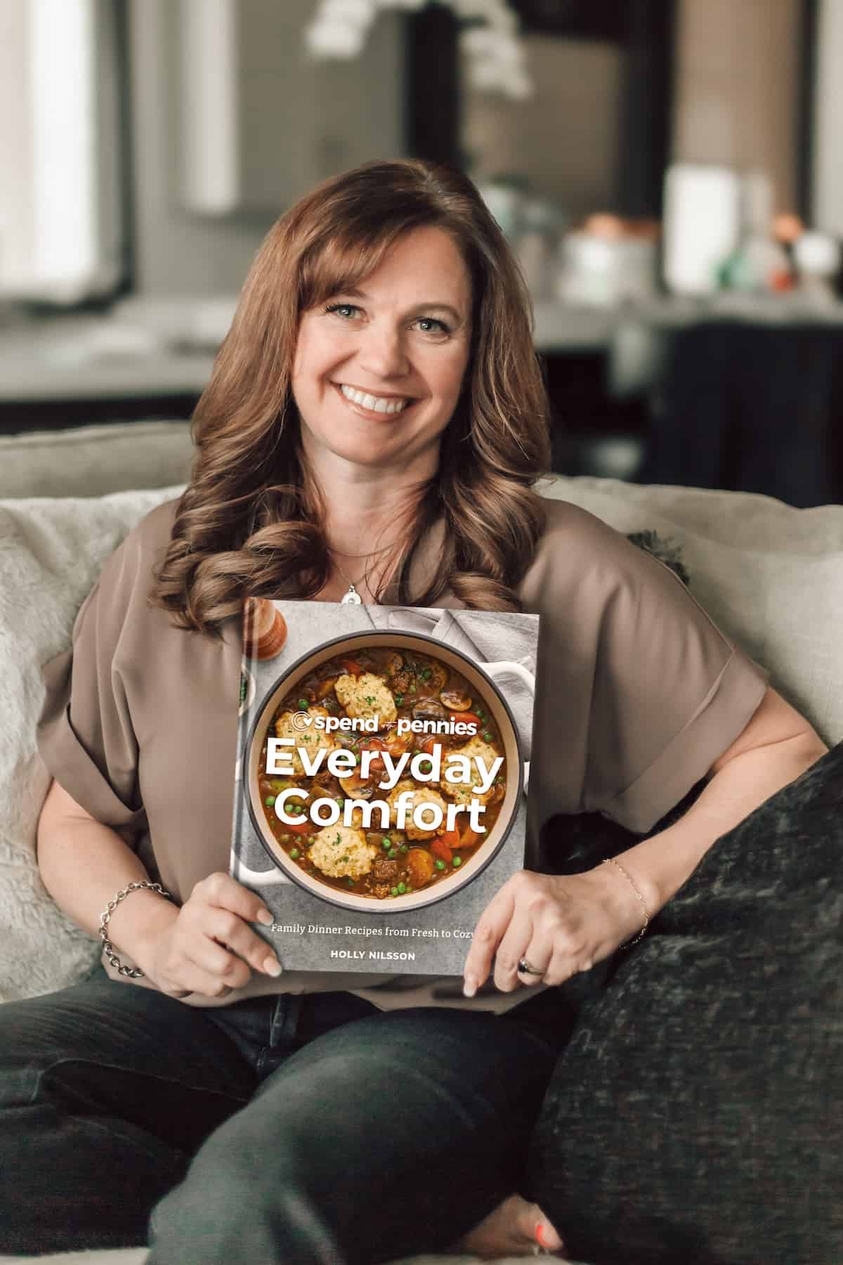 Holly Nilsson from Spend with Pennies holding a copy of Everyday Comfort